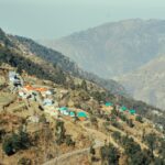 Aerial view of a picturesque village nestled in a tranquil mountain valley with vibrant rooftops.