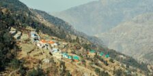 Aerial view of a picturesque village nestled in a tranquil mountain valley with vibrant rooftops.