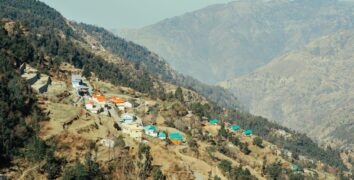 Aerial view of a picturesque village nestled in a tranquil mountain valley with vibrant rooftops.