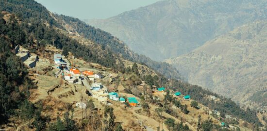 Aerial view of a picturesque village nestled in a tranquil mountain valley with vibrant rooftops.