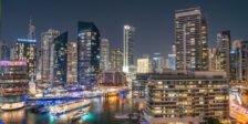 Stunning night view of Dubai Marina with illuminated skyscrapers and reflections on the water.
