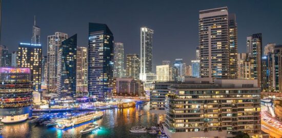 Stunning night view of Dubai Marina with illuminated skyscrapers and reflections on the water.